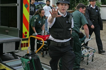 Police officer trying to stop pictures being taken, standing in front of an ambulance and its crew. PPhoto: Nigel Howard