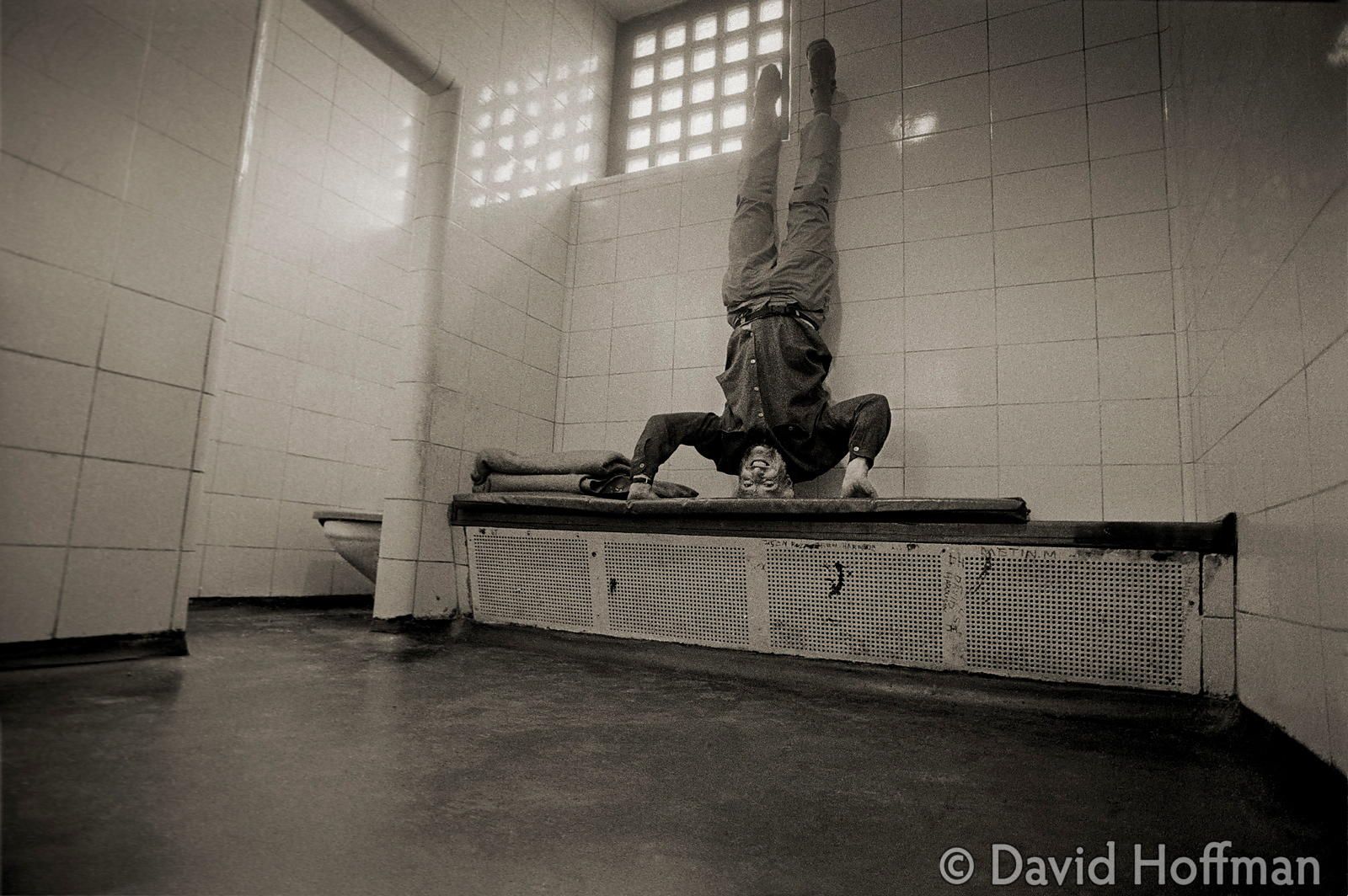 David Hoffman does a head-stand in a police cell
