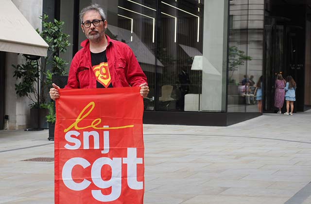 Photo of Pablo Aiquel with SNJ-CGT trade union banner outside TowerBrook in London