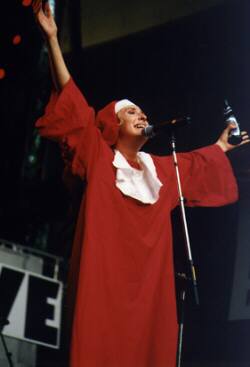 Someone on stage in nun's outfit with a bottle