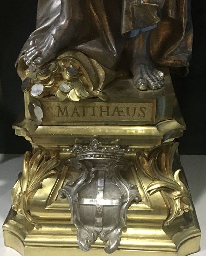 Bag of coins at the feet of St Matthew; Photo: Matt Salusbury